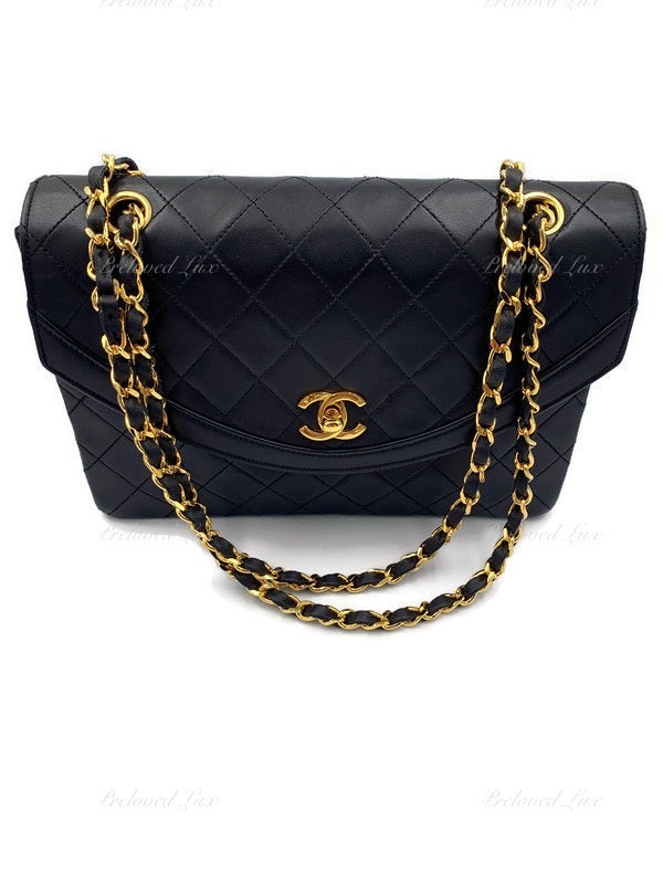 CHANEL Quilted black lambskin bag with rectangular gold…